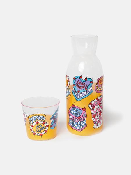 Glaskaraffe mit Glas mit süssem Torten Design auf Nachttisch